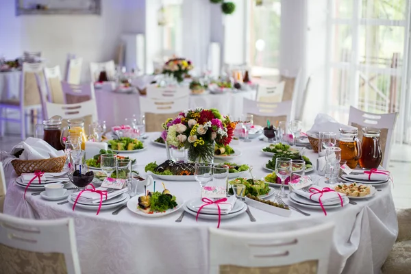 Mesas blancas con flores y comida — Foto de Stock