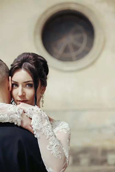 Брюнетка невеста обнимает жениха — стоковое фото