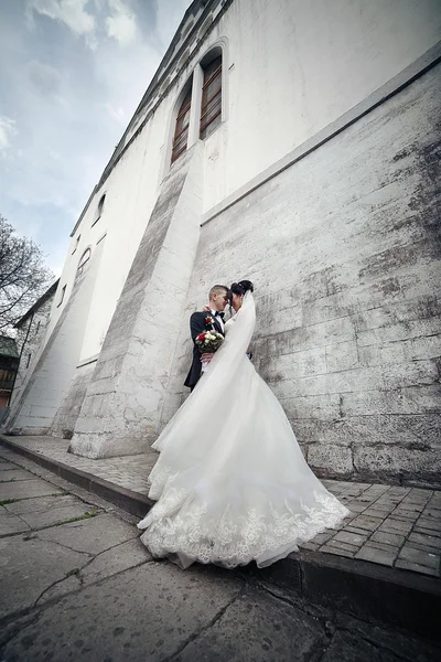 Великолепная брюнетка невеста обнимает жениха — стоковое фото