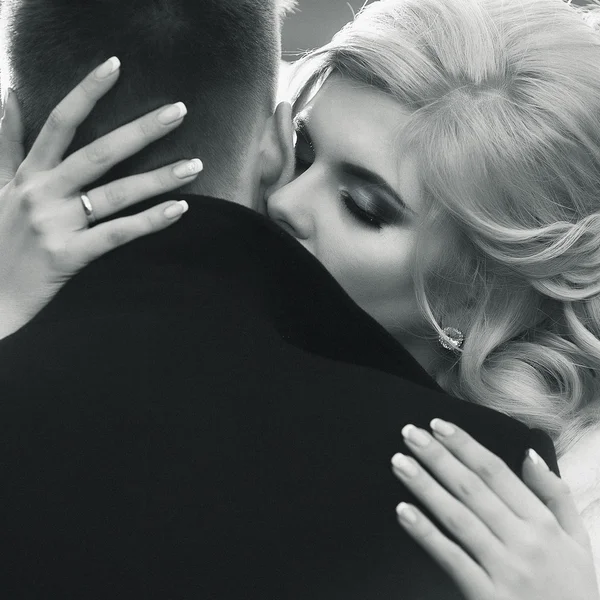 Blonde bride kissing handsome groom — Stock Photo, Image