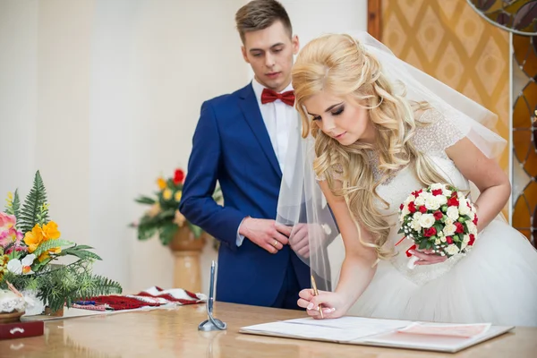 Bruid en bruidegom ondertekening huwelijk — Stockfoto