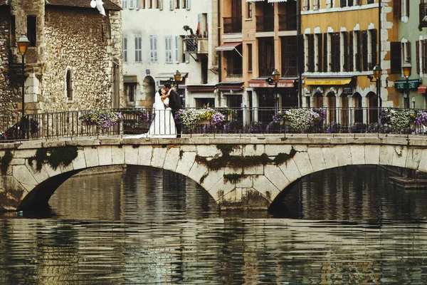 Sposa e sposo che si abbracciano sul vecchio ponte romantico — Foto Stock