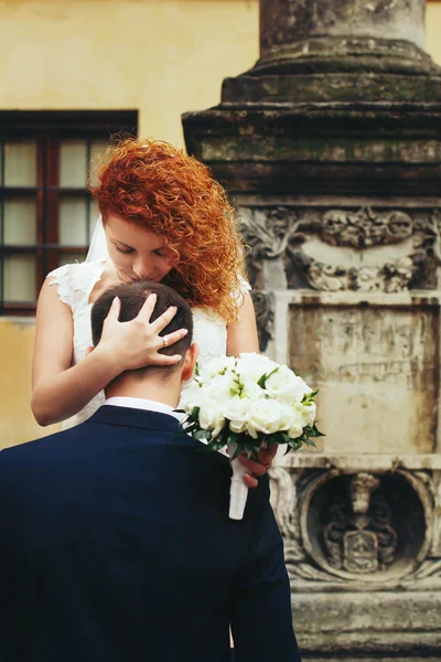 Bruid met rood haar kus bruidegom — Stockfoto