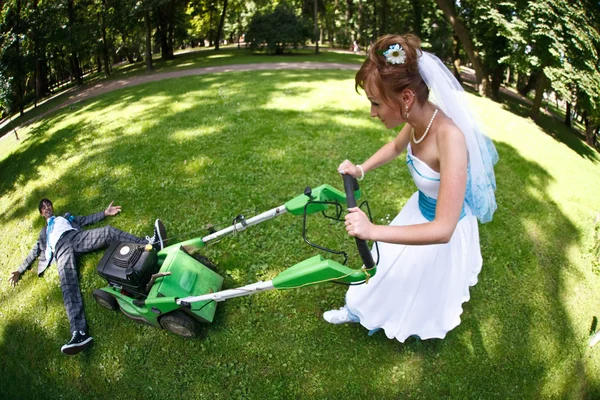 groom on grass and bride with mower