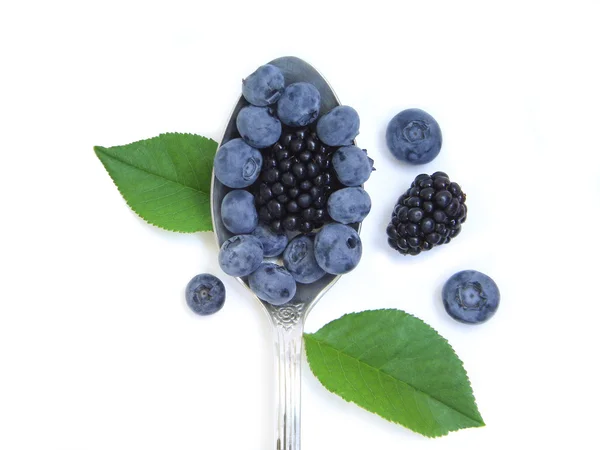 Blueberries and blackberries in a silver spoon — Stock Photo, Image