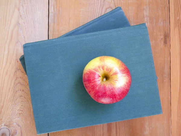 Ripe red Apple  on a book with a green cover — Stock Photo, Image