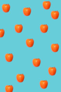 Mavi arka planda güzel ve sağlıklı Japon kaki elmalarından oluşan desen. Düz konsept yatıyordu.