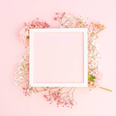 Yaratıcı bahar tebrik kartı tasarımı. Beyaz dallar, pembe çingeneler ve taze karanfiller. Kare kare çerçeveli çiçekler. Pastel pembe parlak arka plan. Paskalya, doğum günü, mutlu kadınlar günü, anneler günü. Düz yerde, üst tarafta. Boşluğu kopyala.