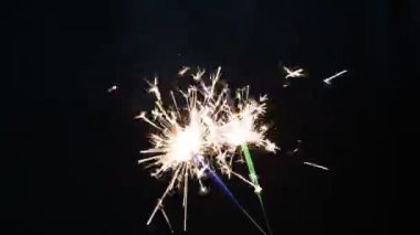 Siyah bir arka planda iki maytap yanıyor.