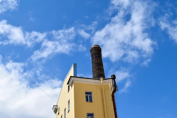 Tower met een pijp op de blauwe hemel. — Stockfoto