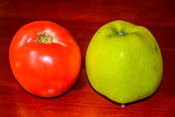 Röd tomat och ett grönt äpple. — Stockfoto