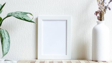 Poster with copy space. Mockup of a wooden frame with home plant ficus with vase with dried flowers. White, minimalism. copy space. Mock up design. Copy space
