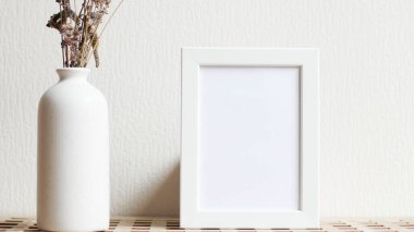Poster with copy space. Mockup of a wooden frame with with vase with dried flowers. White, minimalism. copy space. Mock up design.