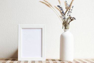 Poster with copy space. Mockup of a wooden frame with with vase with dried flowers. White, minimalism. copy space. Mock up design.
