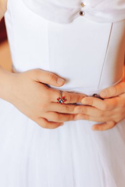 Beyaz elbiseli kız el ele tutuşuyor.