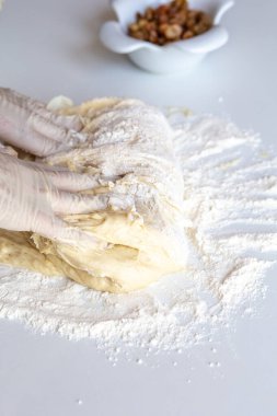 Hamuru un ve kuru üzümle yakın plan beyaz bir masaya dizmek.