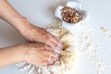 Hamuru un ve kuru üzümle yakın plan beyaz bir masaya dizmek.