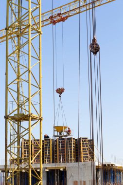 Hidrolik yelken yelkeni vinçleri ve işçilerin temellerine beton dökülüyor. İnşaat alanındaki inşaat çalışmalarına çimento dökülüyor. Kule vinçleri yeni bir yerleşim alanı inşa ediyor.