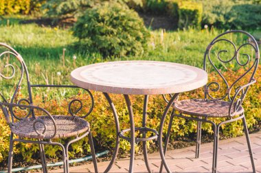 Masa seti, rattan yapılmış sandalyeler ve sırtı metalden yapılmış. Bahçe mobilyası.