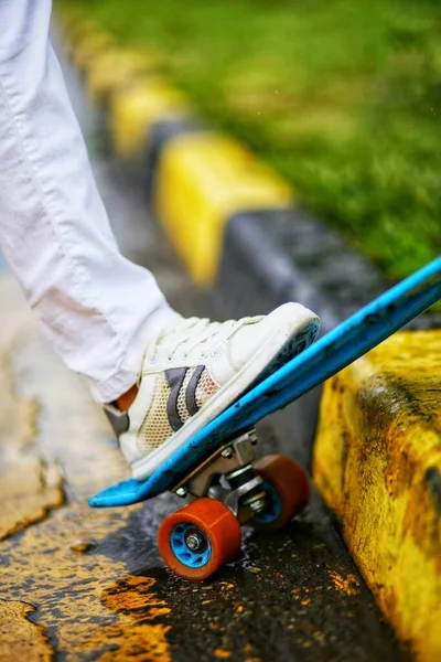 Modrý Skateboard Oranžovými Koly Žlutém Chodníku Deštivý Den Zblízka — Stock fotografie