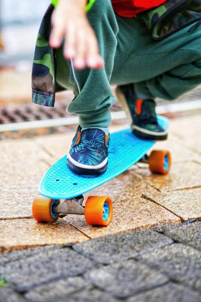 Modrý Skateboard Oranžovými Koly Žlutém Chodníku Deštivý Den Zblízka — Stock fotografie