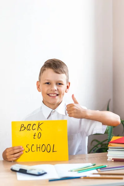 Feliz Colegial Rubio Una Camisa Blanca Sienta Escritorio Sobre Fondo —  Fotos de Stock