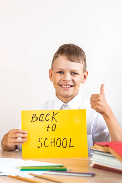 Feliz Colegial Rubio Una Camisa Blanca Sienta Escritorio Sobre Fondo — Foto de Stock