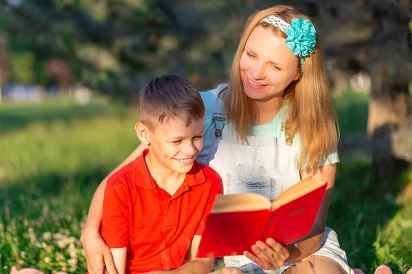 Blondynka Mama Syn Czerwonym Shircie Czytają Książkę Czerwoną Okładką Naturze — Zdjęcie stockowe