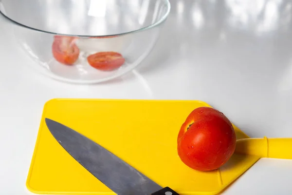 Tomates hachées et couteau sur planche à découper jaune. — Photo