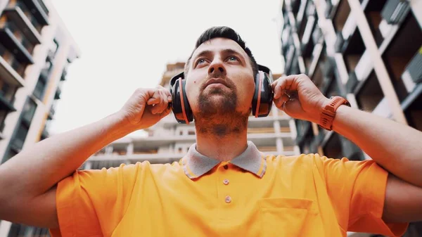 Güvenlik ekipmanı takan adam işitme korumalı. Ses çıkartan kulaklık ya da kulaklık takan bir işçi. İnşaatçı kulaklıkla koruyucu kulaklık takıyor. İş sırasında güvenliği sağlamak..