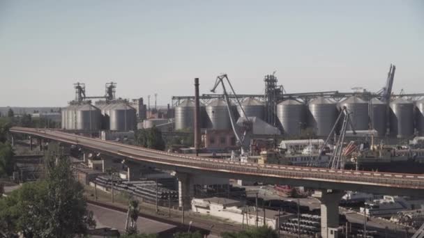 Uma vista panorâmica de uma altura dos edifícios do porto, o sistema logístico, armazenamento de mercadorias e guindastes, estradas para transporte e caminhões. O tema da economia do Estado e — Vídeo de Stock