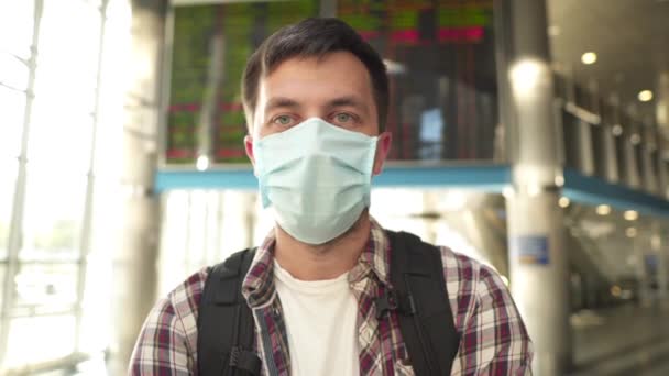 Biały turysta noszący maskę ochronną na twarzy, pokazujący kciuki w górę podczas podróży koronawirusem lub wybuchem choroby wieńcowej 19, nowa normalna koncepcja. Modna osoba zakrywająca maskę chirurgiczną i gestykulująca dobrze — Wideo stockowe