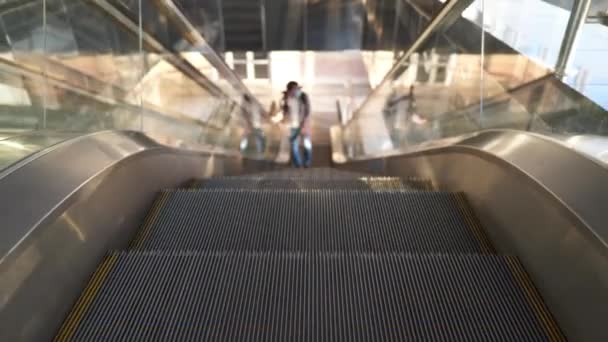 Leeres Bahnhofsgebäude, einsamer Fahrgast auf der Rolltreppe, der während der Vollsperrung eine Schutzmaske trägt. Annullierungen von Flügen und Transport brechen zusammen. Passagier steigt auf Rolltreppe — Stockvideo