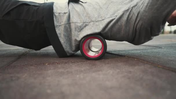 Kaukasischer Mann mit Schaumstoffmassagerolle zur Massage und Entspannung der Rückenmuskulatur nach dem Workout im Outdoor-Fitnessstudio. Tiefengewebemassage mit Vibrationsphysiotherapie Foam Roller. Rückenschmerzen — Stockvideo