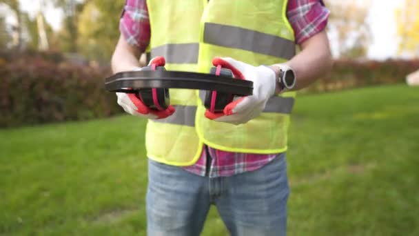 Muž s ochranou sluchu v solární elektrárně. Inženýr nosí hluk rušící sluchátka nebo sluchátka proti solárnímu panelu. Foreman si nasadí ochranné uši se sluchátky — Stock video