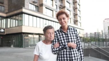 Hemşire yaşlılara bakıyor. Gönüllü hemşire yaşlı kadına sarılır, gülümser, mutludur, avluda yürür. Pansiyon kavramı, huzurevi, yaşlılara yardım. Olgun kız büyükannesini ziyaret ediyor.