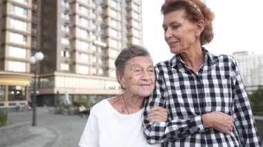 Hemşire yaşlılara bakıyor. Gönüllü hemşire yaşlı kadına sarılır, gülümser, mutludur, avluda yürür. Pansiyon kavramı, huzurevi, yaşlılara yardım. Olgun kız büyükannesini ziyaret ediyor.