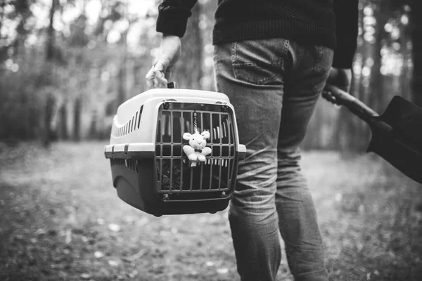 Yasadışı hayvan gömme teması. Ormanda self-servis hayvan mezarı. İnsan, yanında ölü kedi ya da köpek ve ormana gömmek için büyük bir kürek taşıyan taşıyıcı taşır. RIP evcil hayvan.