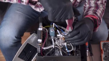 Kahve makinesi tamir servisi. Tamirci, mutfak elektronik aletlerini tamir ediyor. Ev aletleri tamir konsepti. Ev aletlerinin tamircisini ara. Bozuk kahve makinesini tamir eden adam.