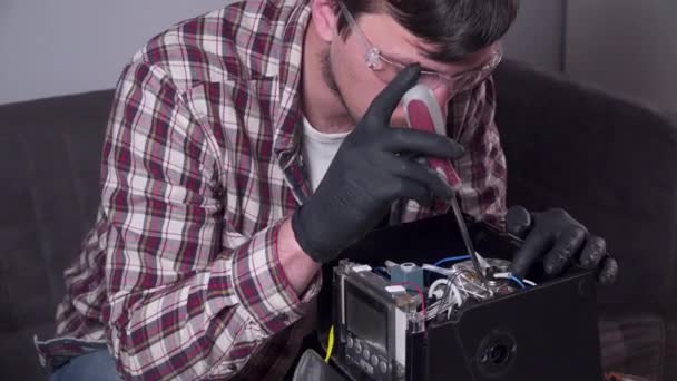 Tratando de arreglar la cafetera. Servicio y reparación de cafetera. Handyman adulto reparación de la máquina de café por destornillador en casa. Masculino reparar el percolador en gafas y guantes de goma negro — Vídeo de stock