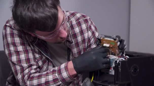 Tratando de arreglar la cafetera. Servicio y reparación de cafetera. Handyman adulto reparación de la máquina de café por destornillador en casa. Masculino reparar el percolador en gafas y guantes de goma negro — Vídeos de Stock