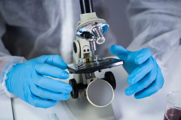 Lekarz Białym Kombinezonie Ochronnym Patrzący Przez Mikroskop Laboratorium Chemicznym Szukaj — Zdjęcie stockowe