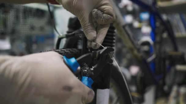 El mecánico de bicicletas repara y mantiene la bicicleta del cliente de acuerdo con los estándares de cuarentena durante la pandemia de coronavirus, usa máscara médica y guantes. Transporte individual durante el bloqueo covid 19 — Vídeo de stock