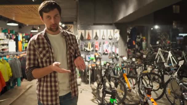 판매 보조원은 스포츠 용품 점에서 자전거를 선택하는 데 도움을 준다. 자전거 가게 점원은 고객에게 조언 한다. 남자 자전거 가게 주인은 카메라상의 자전거에 대해 이야기 합니다. 남자가 자전거에 관한 비디오 블로그를 이끌고 있어요 — 비디오