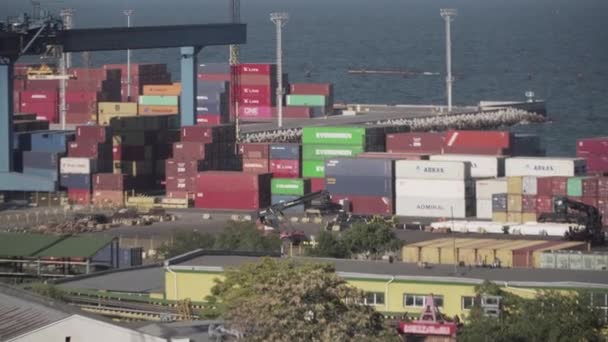 Ukrajina. Odessa, 11. srpna 2020.Přehled stavění námořního přístavu se skladištěm vícebarevných námořních kontejnerů na pozadí moře, v rámu jeřábů a kolového nakladače. Téma práce v průmyslu. — Stock video