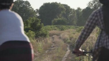 Manzaralı yolda bisiklete binen aktif bir çift. Kırsalda dağ bisikleti süren spor bir çift. Sağlıklı Yaşam Tarzı Konsepti. Spor, spor, insanlar ve bisiklet. Mutlu erkek ve kadın dışarıda bisikletle egzersiz yapıyor.