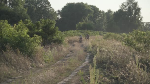 Mężczyzna i kobieta jeździć rowery górskie razem na wiejskiej drodze w lecie natury, słoneczna pogoda. Kilku rowerzystów aktywnie trenuje na świeżym powietrzu. Rodzinny weekend sportowy. Ludzie, wolny styl życia — Wideo stockowe