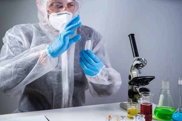 Coronavirus için ilaç geliştirme ve arama. Kimyager enjeksiyon için antibiyotik tozu ampulünü inceliyor. Bakteriyel enfeksiyonu ilaçlarla tedavi etmek. Covid 19 sağlık ve tedavi kavramı.
