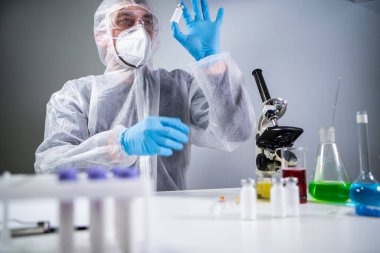 Coronavirus için ilaç geliştirme ve arama. Kimyager enjeksiyon için antibiyotik tozu ampulünü inceliyor. Bakteriyel enfeksiyonu ilaçlarla tedavi etmek. Covid 19 sağlık ve tedavi kavramı.