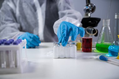 Coronavirus için ilaç geliştirme ve arama. Kimyager enjeksiyon için antibiyotik tozu ampulünü inceliyor. Bakteriyel enfeksiyonu ilaçlarla tedavi etmek. Covid 19 sağlık ve tedavi kavramı.